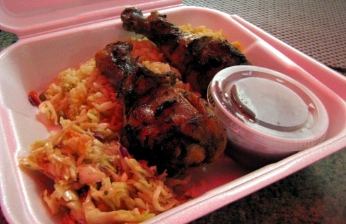 Jerk chicken legs with fusion slaw and blackberry dipping sauce.